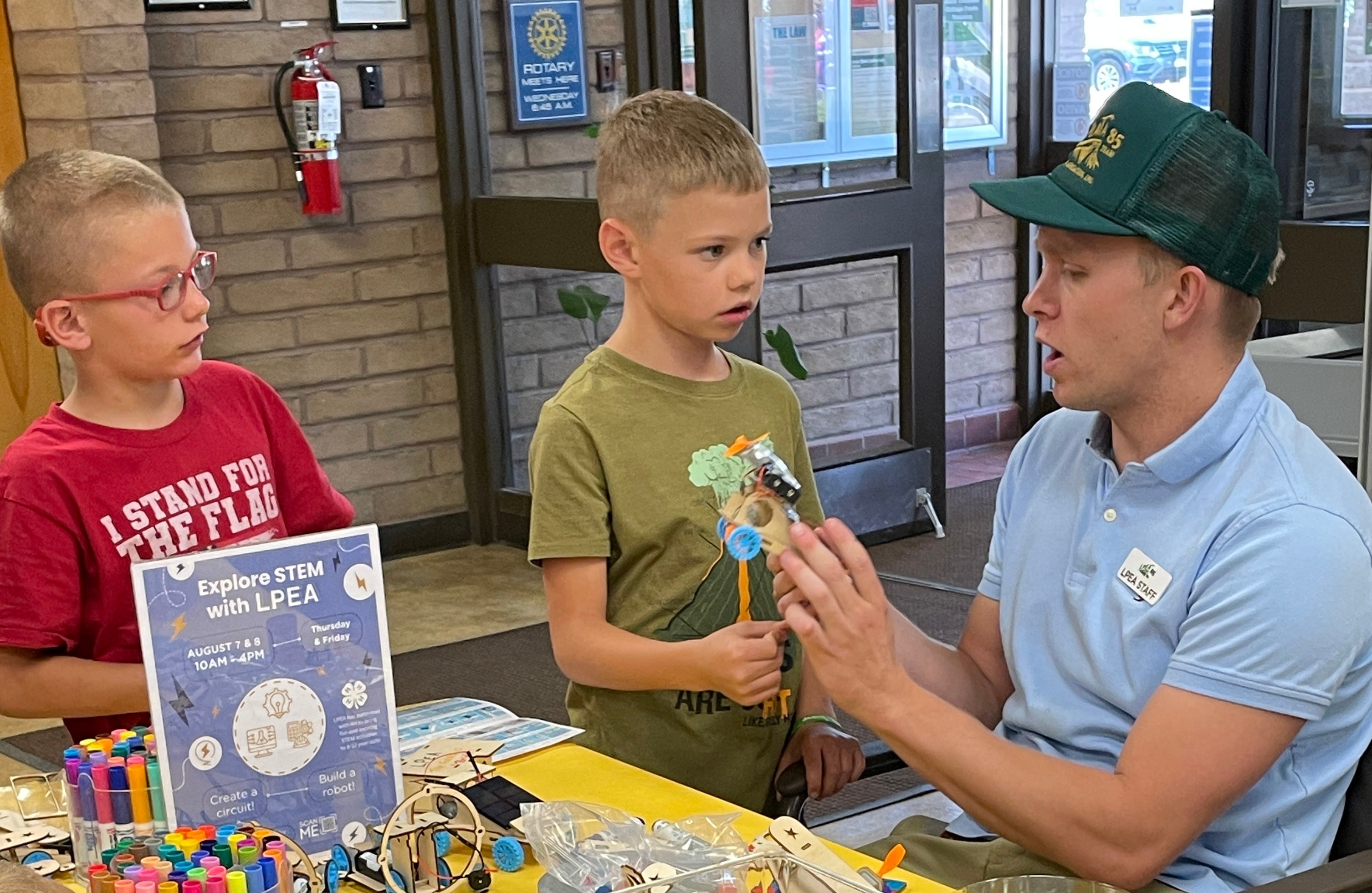 A man helps kids with STEM project