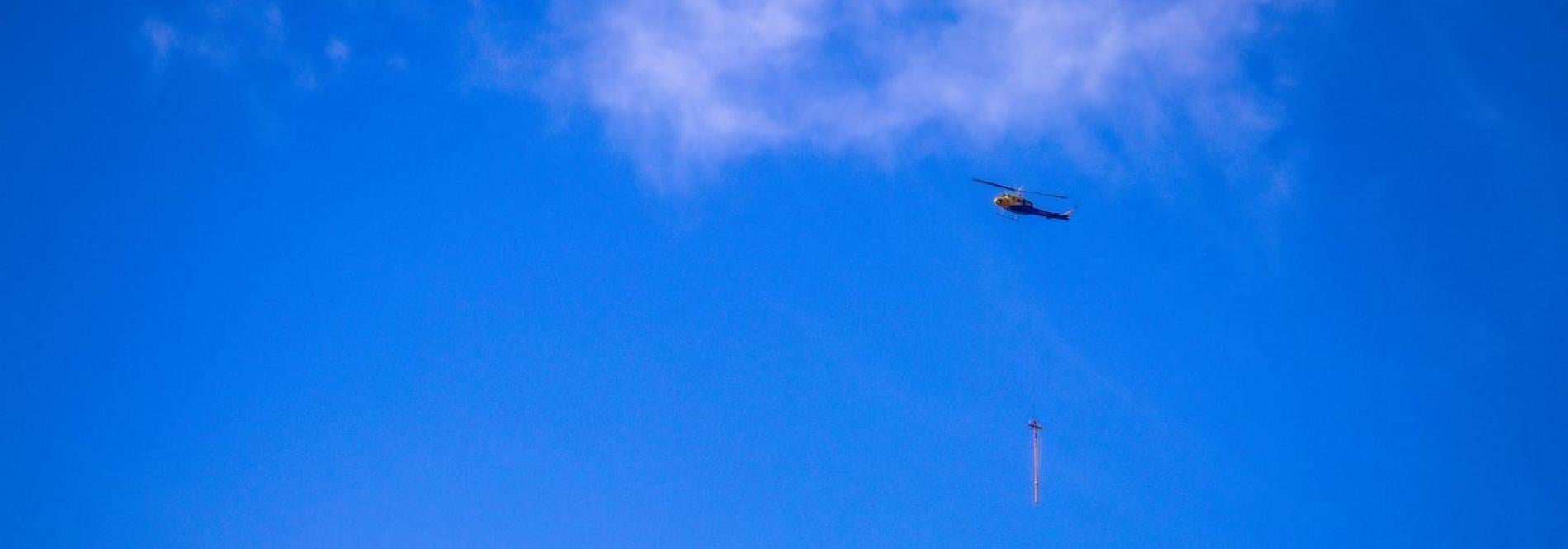 Helicopter carrying a power pole