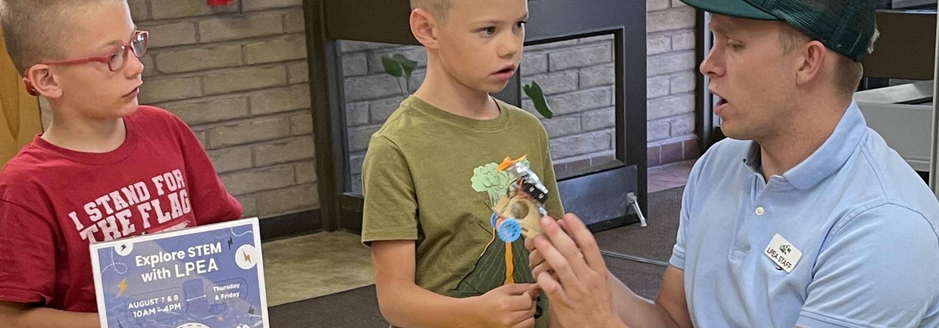 A man helps kids with a science project at the county fair
