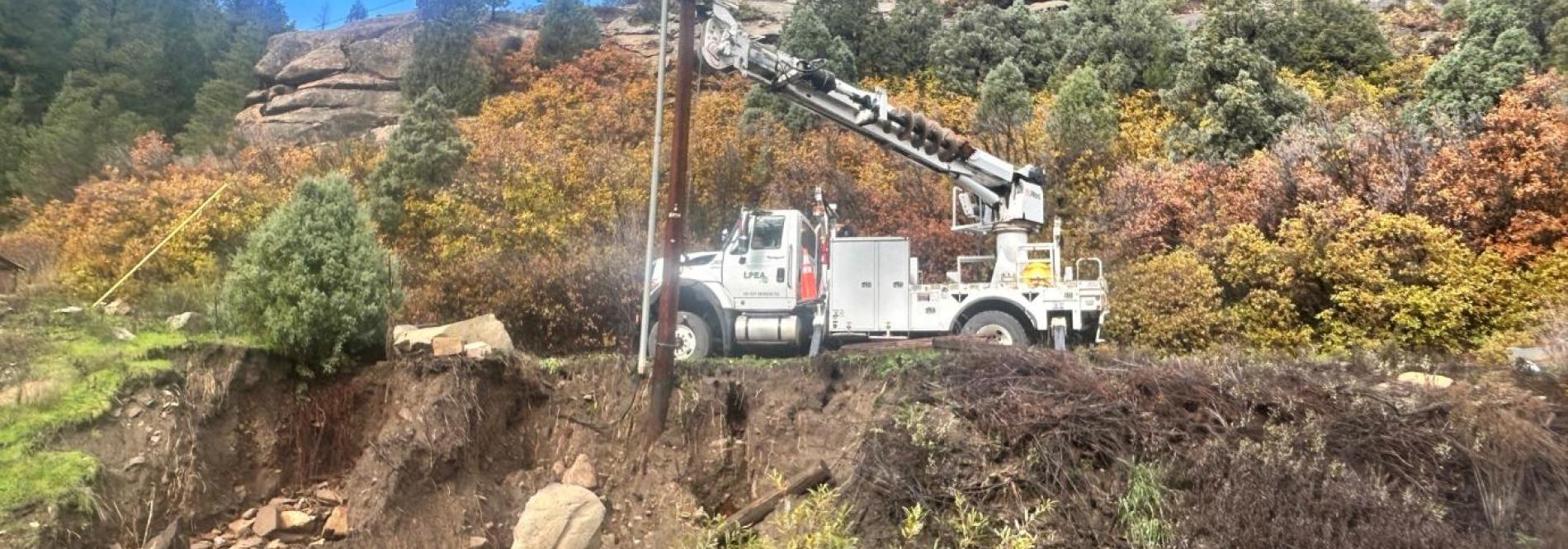Truck holds a power pole in place after flooding